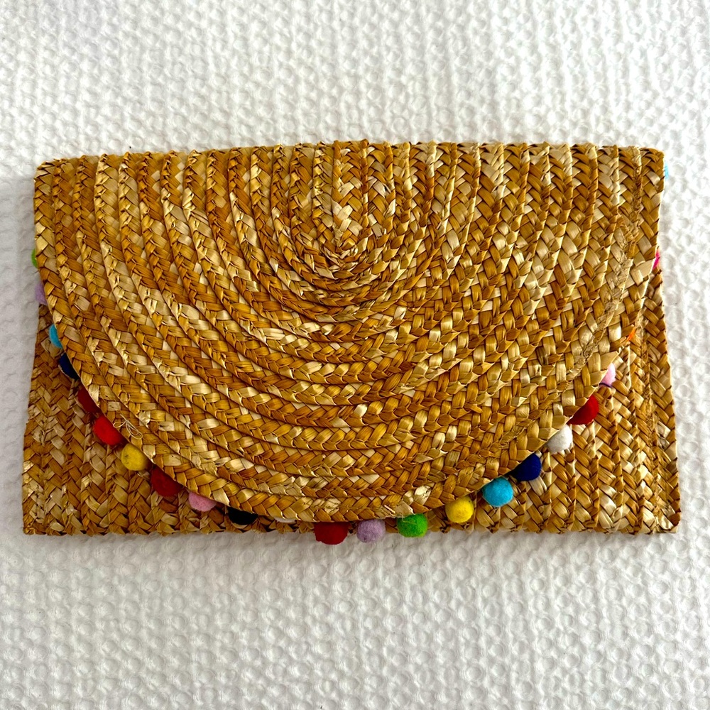 Hand woven clutch with colorful pom-pom details